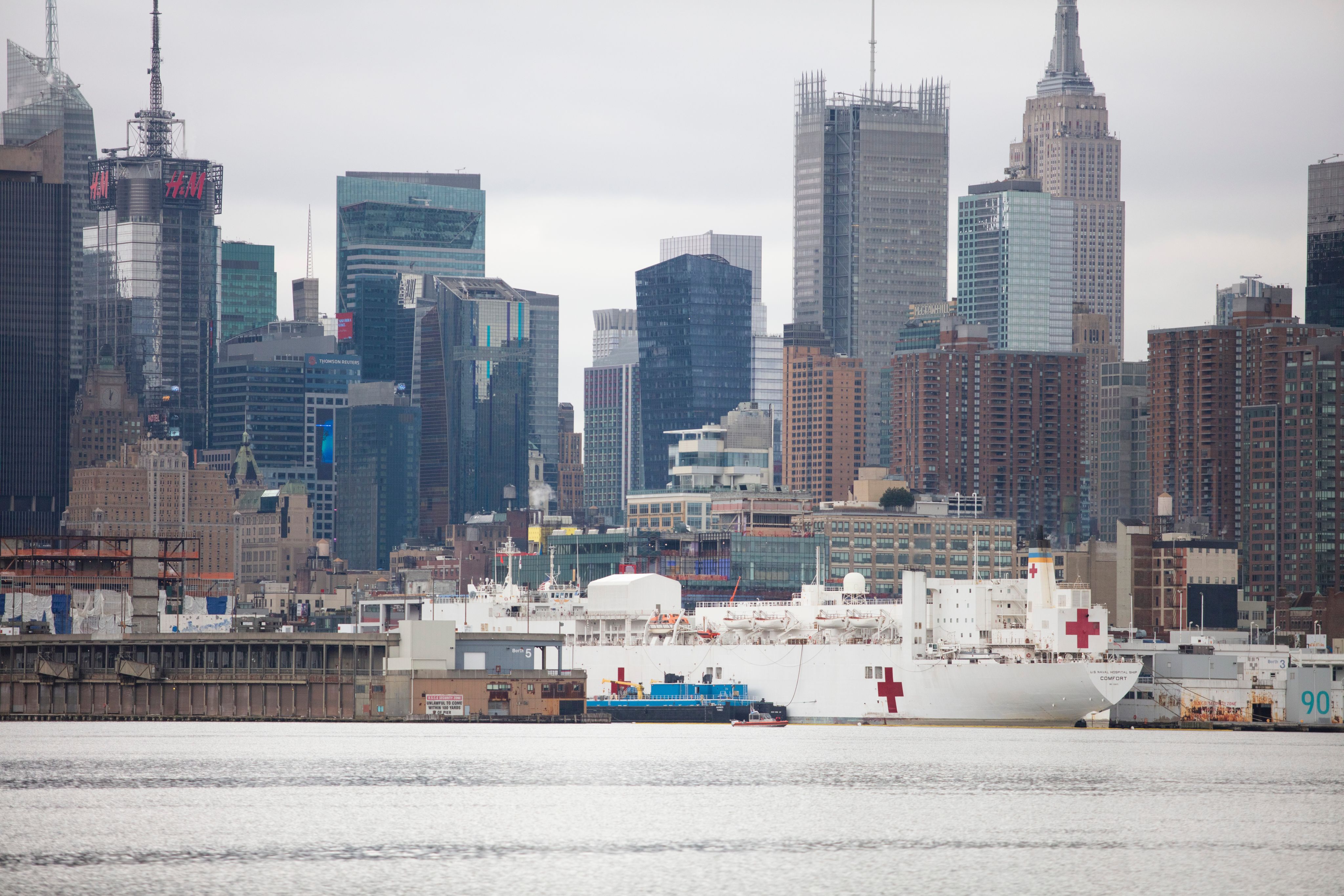 white ship on body of water near city buildings during daytime